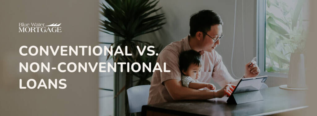 A father with a toddler on his lap, sitting at home working on a tablet at a table
